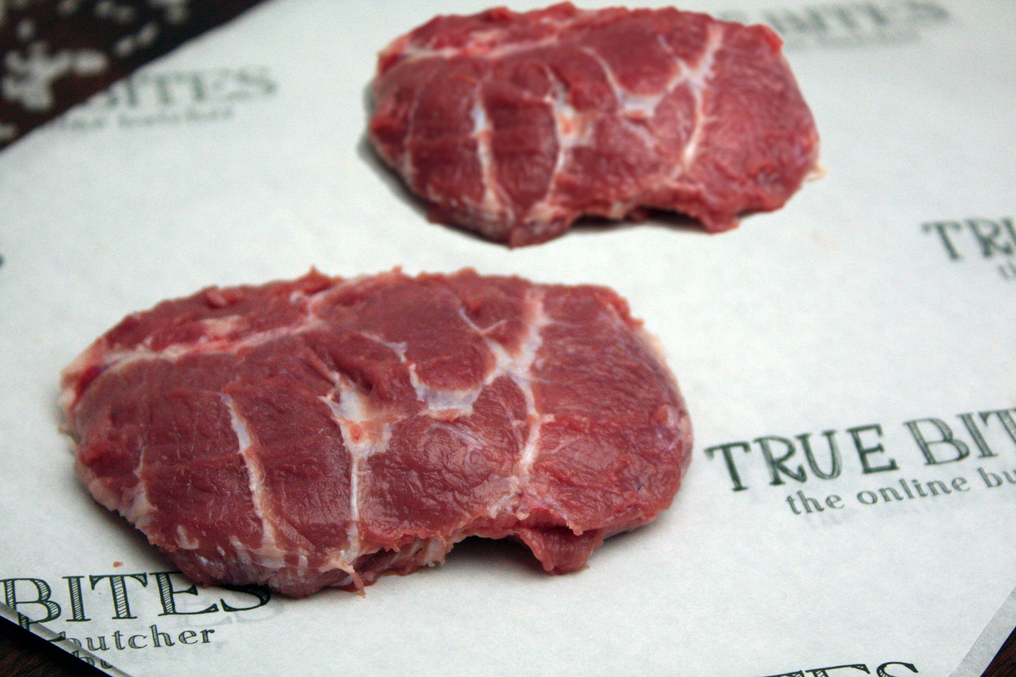 two pigs cheeks displayed on true bites greaseproof paper