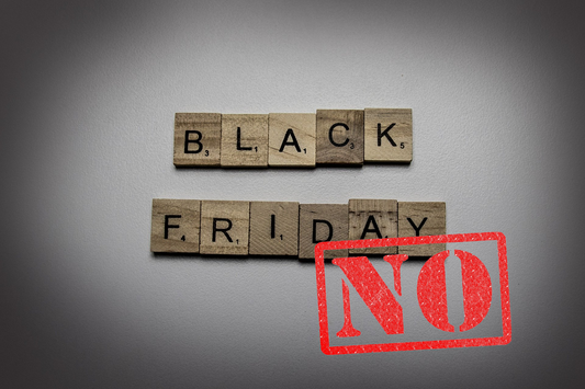 black friday written out in scrabble letters with a no stamped over the top