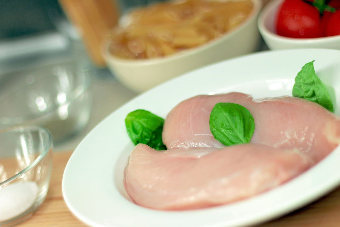 2 raw chicken breast on a white plate