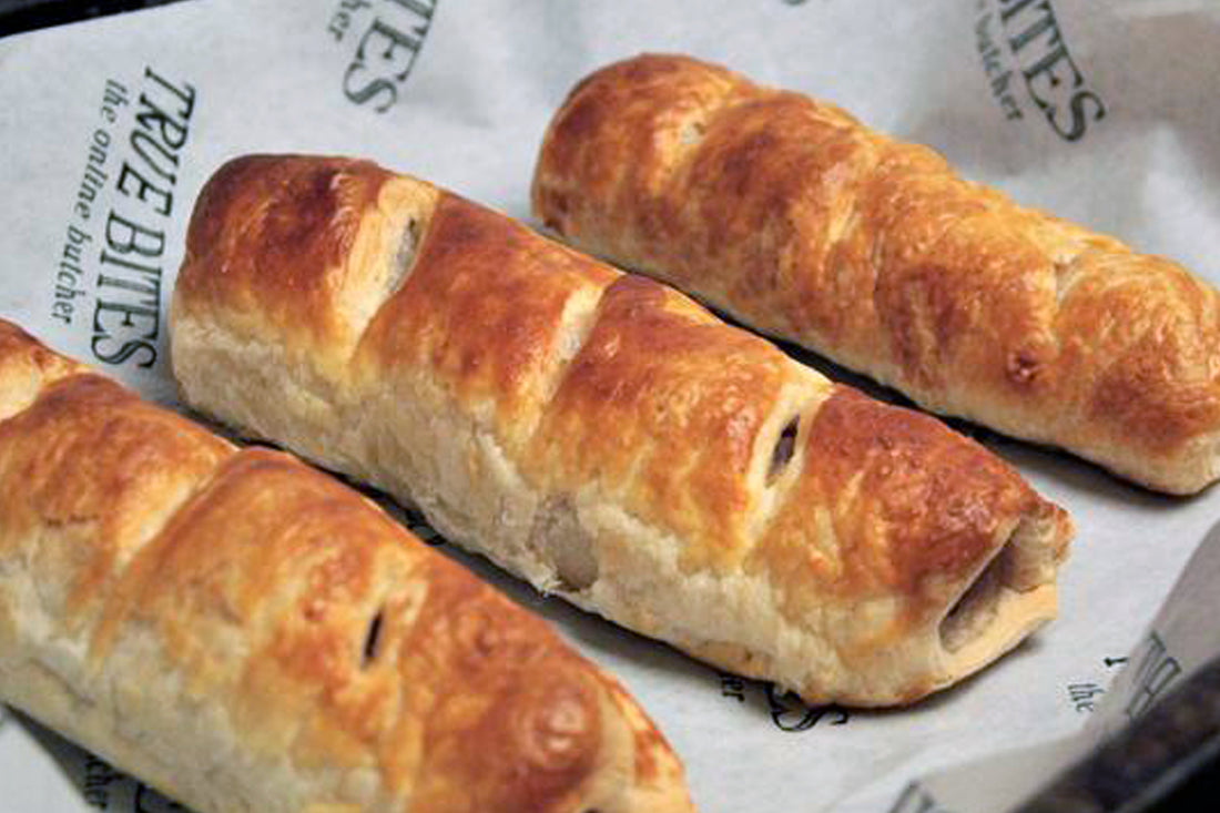 homemade sausage rolls displayed on true bites branded greaseproof paper