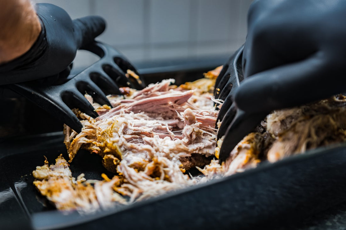 pork roast being pulled apart using two large forks