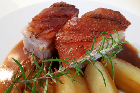 pork belly with crispy crackling on a bed of potatoes 