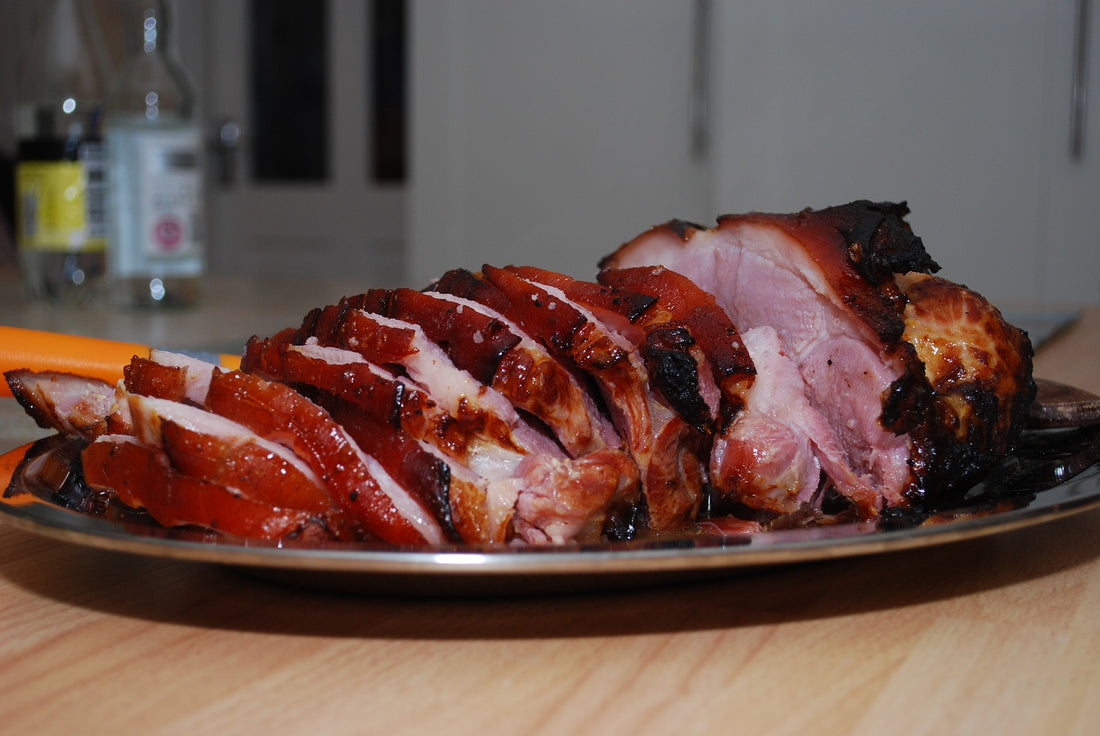 Sliced roasted gammon joint displayed on a silver plate