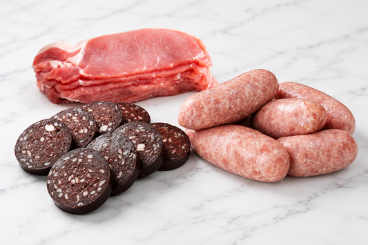 raw bacon, sausage and black pudding on a white marble surface