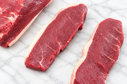 2 sliced beef picanha steaks on wooden cutting board
