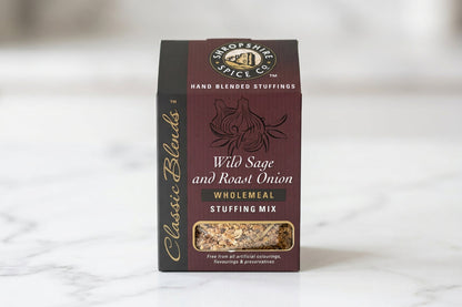 A box of Hand Blended Stuffings Classic Blends 'Wild Sage and Roast Onion' Wholemeal Stuffing Mix on a white tabletop with a blurred indoor background.