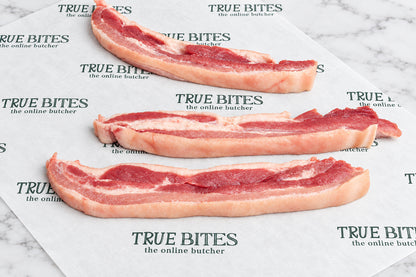 3 raw sliced pork belly strip on true bites branded butcher paper