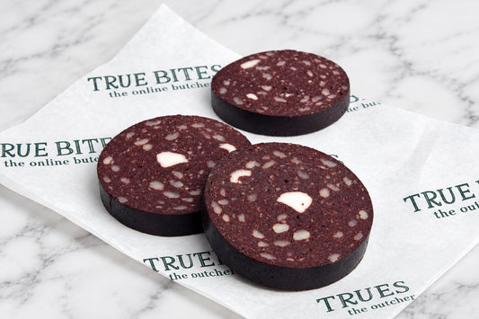 sliced black pudding displayed on true bites branded greaseproof paper
