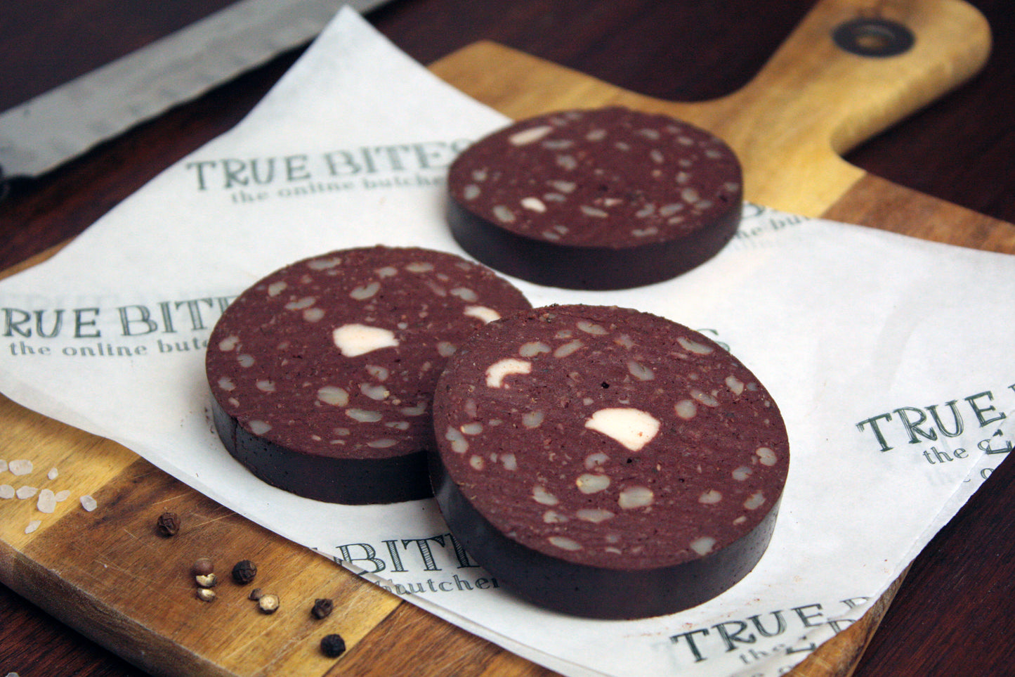 sliced black pudding displayed on true bites branded greaseproof paper