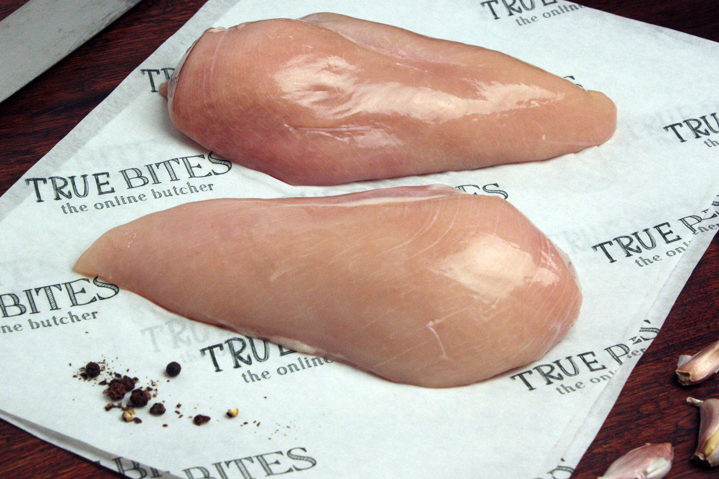 2 raw chicken fillets on true bites branded greaseproof paper