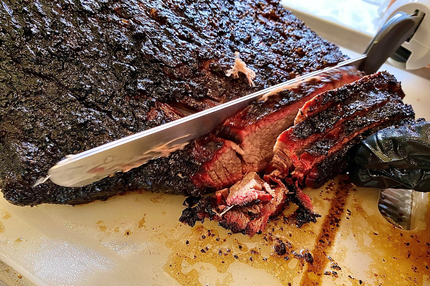 whole smoked brisket being sliced