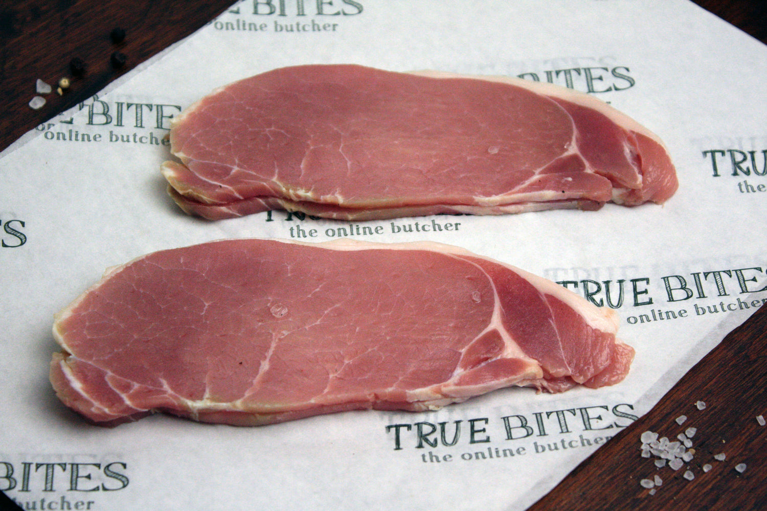 dry cured back bacon sitting on true bites branded greaseproof paper