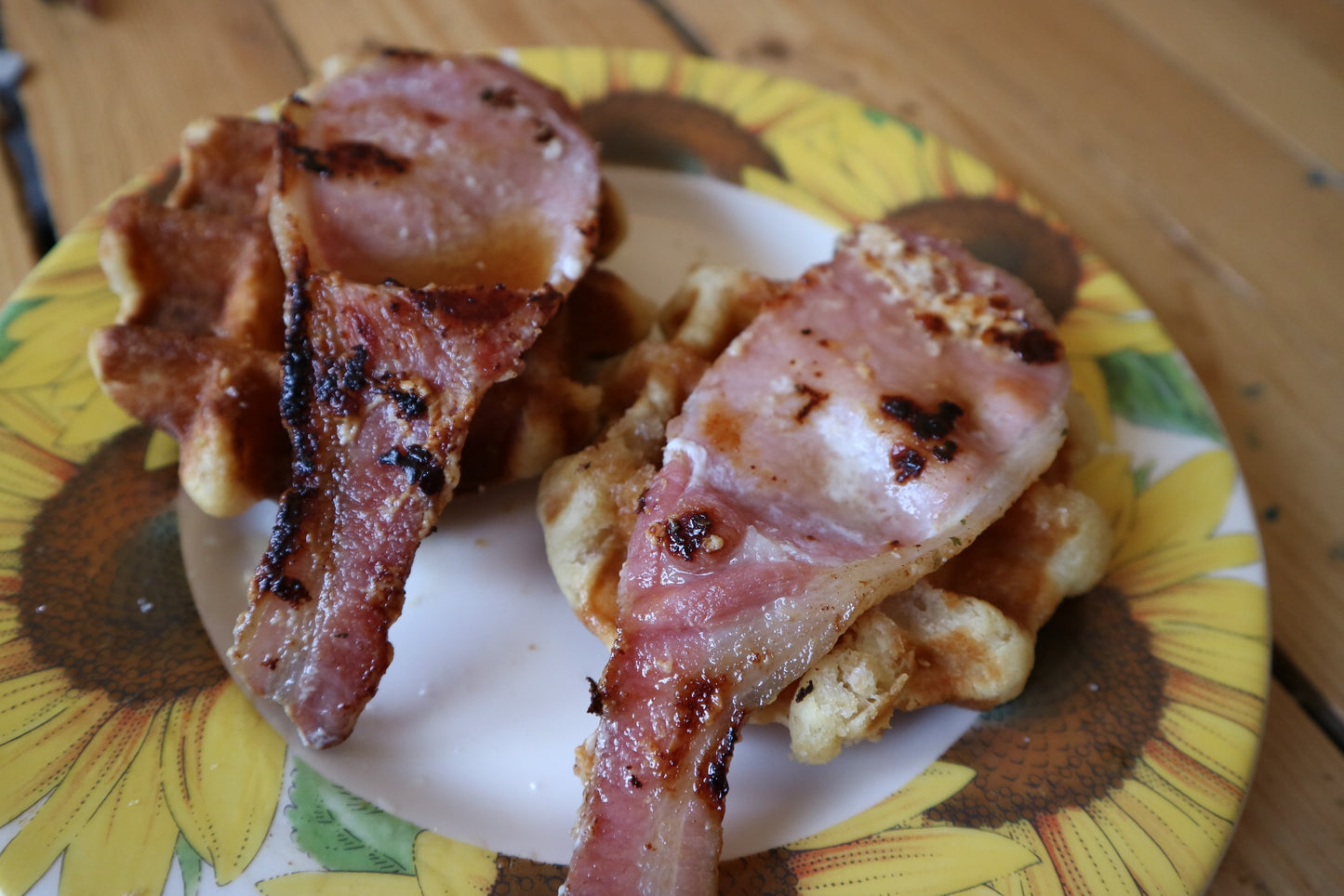 fried maple bacon on top of waffles on a plate