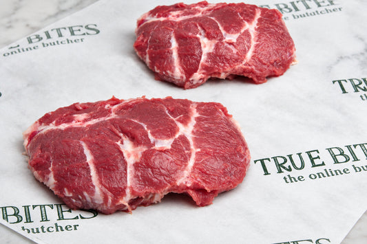 two pigs cheeks displayed on true bites branded greaseproof paper