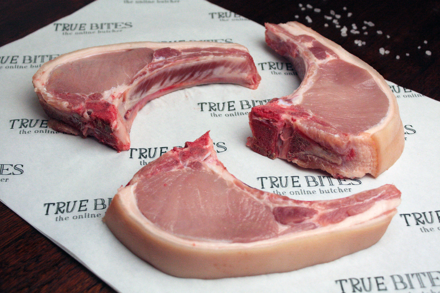 three pork loin chops displayed on true bites greaseproof paper