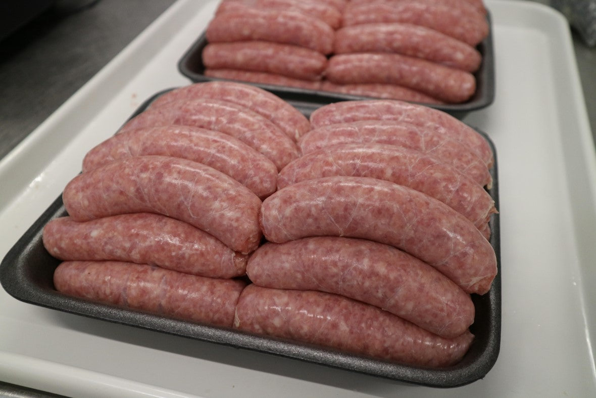 black tray filled with thick premium pork sausages