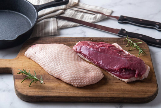 raw duck breast on wooden chopping board 