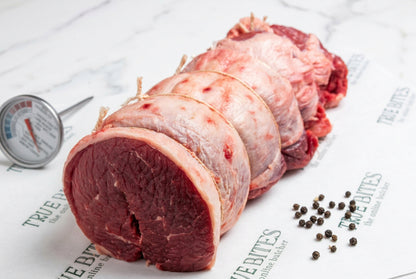 a strung boneless rolled beef brisket on branded butcher paper reading TRUE BITES the online butcher.