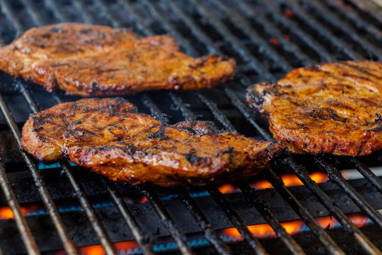 lamb steaks cooking on a bbq grill 